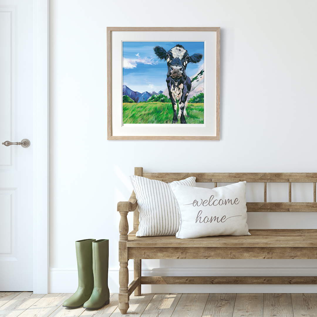Dairy cow art print hanging in a farmhouse hallway with wellies